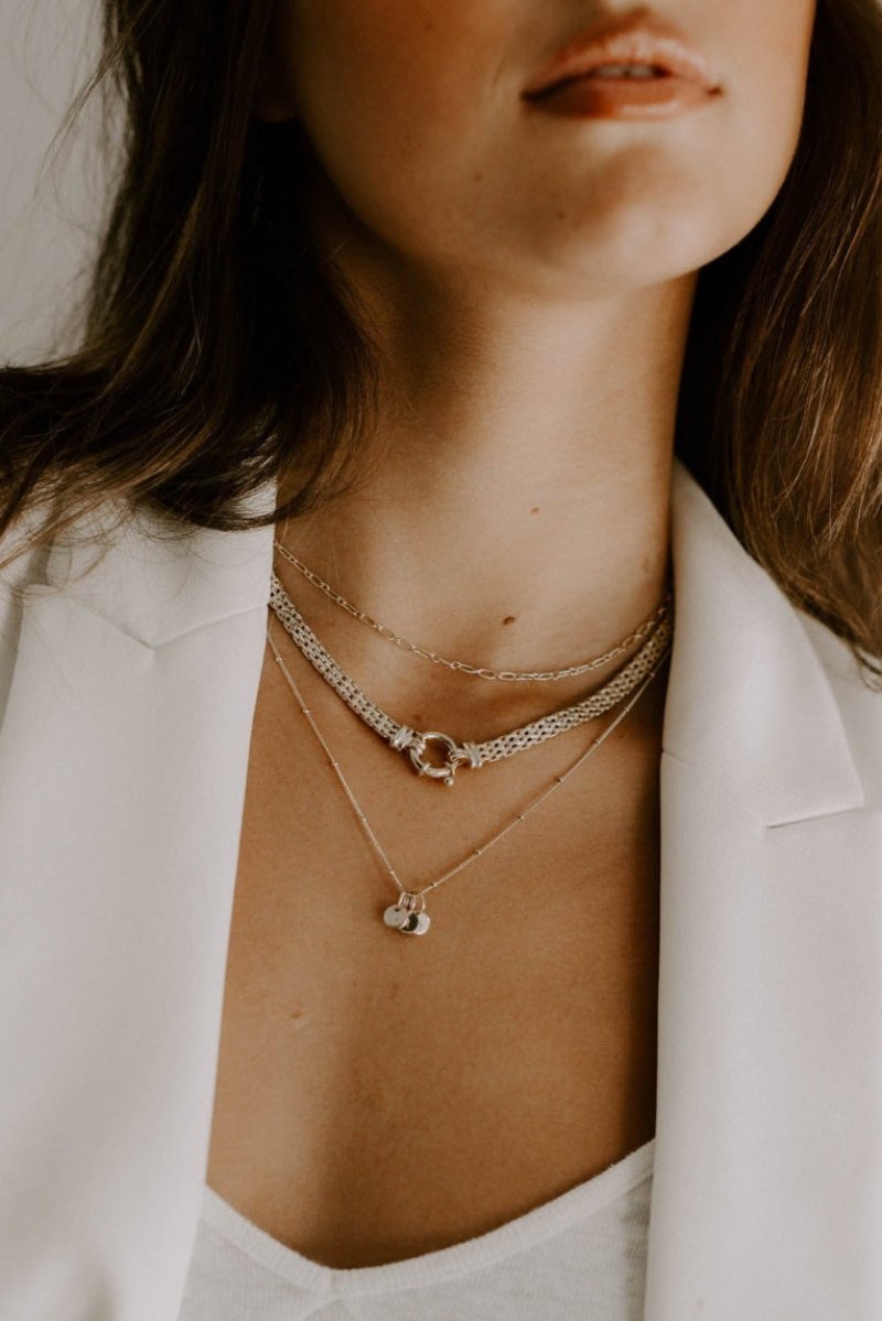 The Petite Initial pendants are shown on a ball chain necklace as part of a series of 3 layered necklaces 