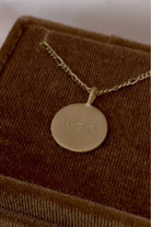 A Gold Signature Necklace with personalised engraving on it sitting inside a Bluebird Co velvet box