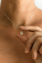 A close up look at the detailing inside the vintage pearl pendant on the ball chain necklace 