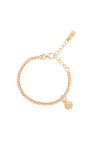 A detailed image of a gold Lace Chain bracelet with a mermaid shell charm, designed as an elegant and whimsical piece of jewellery.
