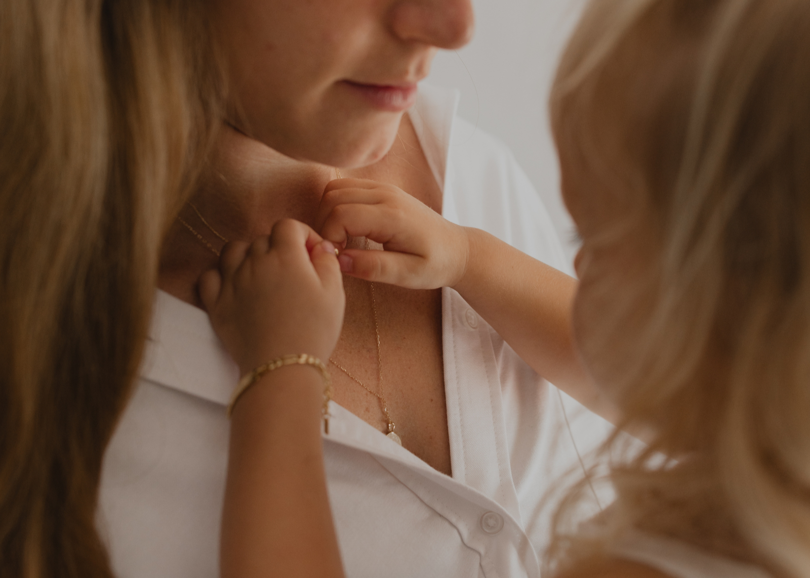 A close-up photo of mum with baby wearing a Lumé Necklace by Bluebird Jewellery, inspired by the French word for ‘light,’ crafted as a radiant symbol of warmth and kindness.