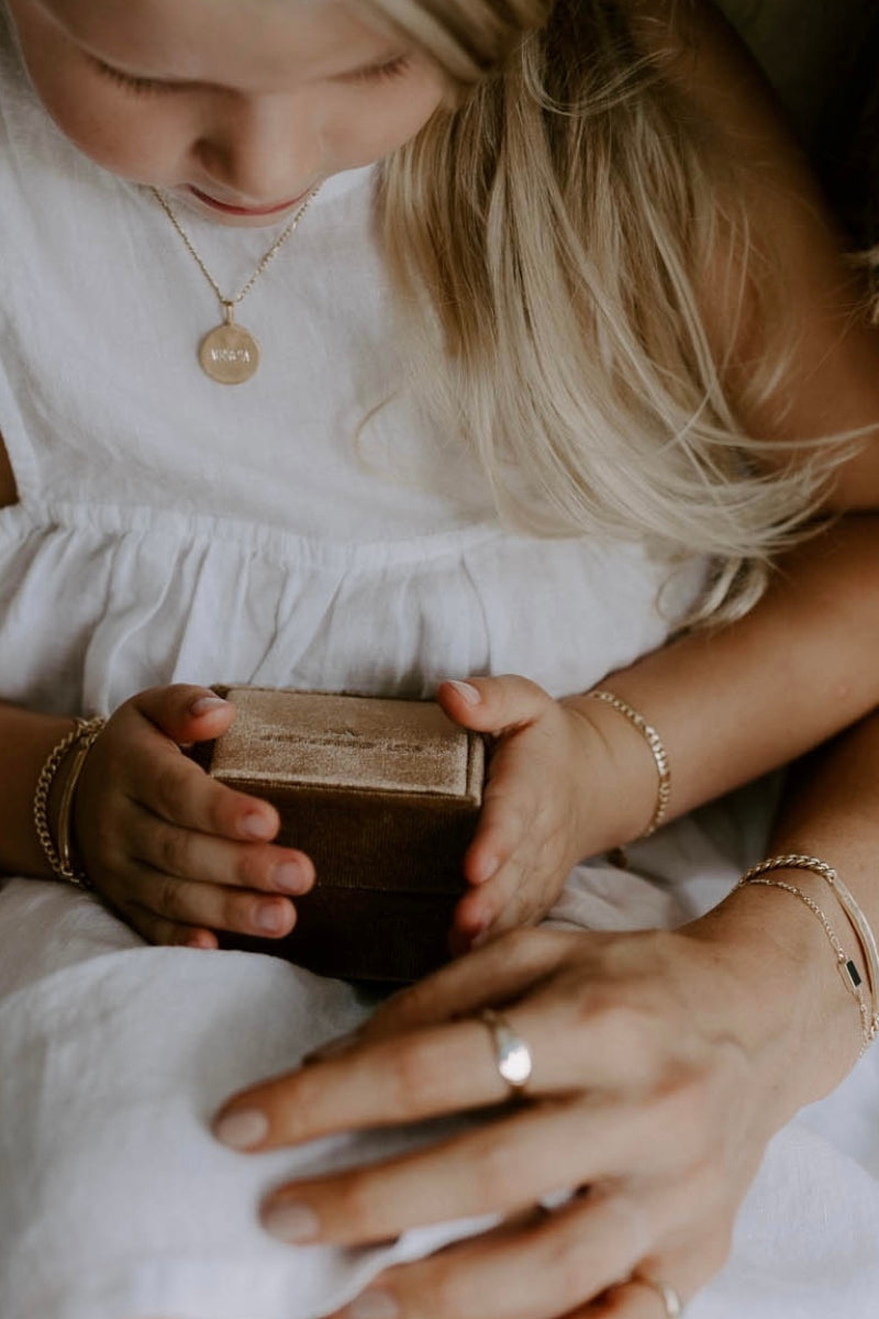 Personalised jewellery gift box is being looked at by a mother and her daughter.  The mother and daughter are both wearing matching Bluebird Co Signature Bracelets.