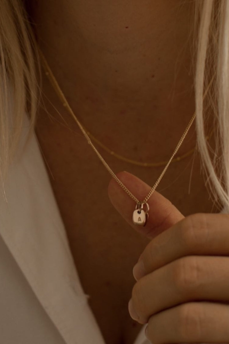 A fine curb chain necklace with the Mini Rectangular Pendants Bluebird Jewellery features gentle curves and a luxe, modern silhouette. Personalised with your chosen letter, it embodies feminine elegance and can be worn beautifully on any necklace, bracelet, or anklet chain.