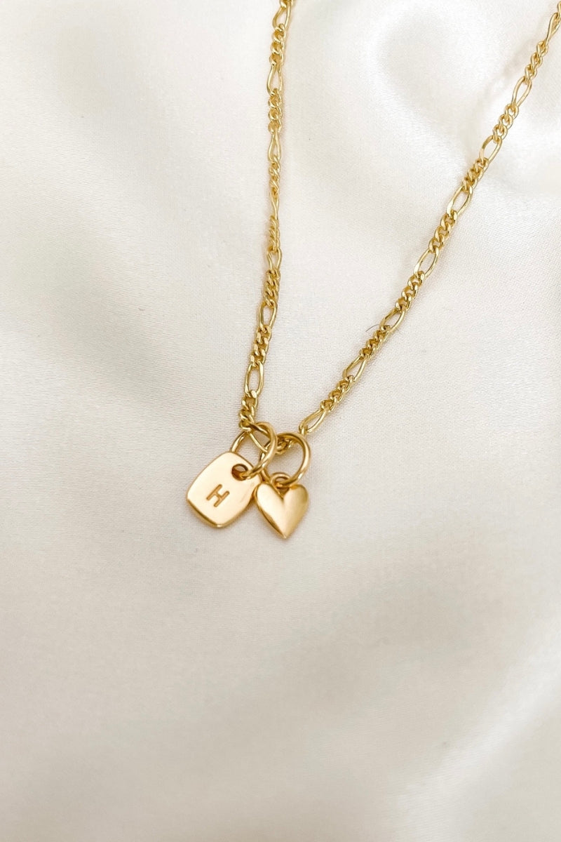 A signature Figaro Necklace with a Mini Rectangular Pendant and heart pendant by Bluebird Jewellery features gentle curves and a luxe, modern silhouette. Personalised with your chosen letter, it embodies feminine elegance and can be worn beautifully on any necklace, bracelet, or anklet chain.