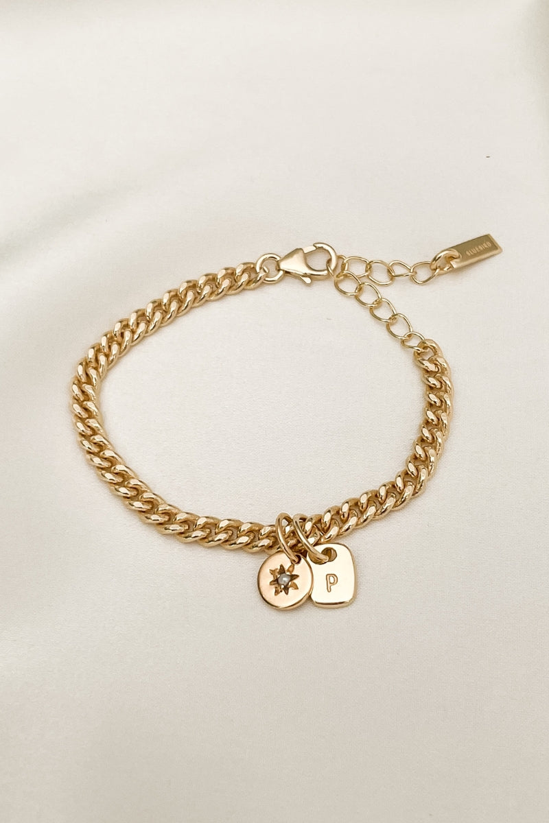 The Cuban Chain bracelet with Daisy pendant and Mini Rectangular Pendant by Bluebird Jewellery features gentle curves and a luxe, modern silhouette. Personalised with your chosen letter, it embodies feminine elegance and can be worn beautifully on any necklace, bracelet, or anklet chain.