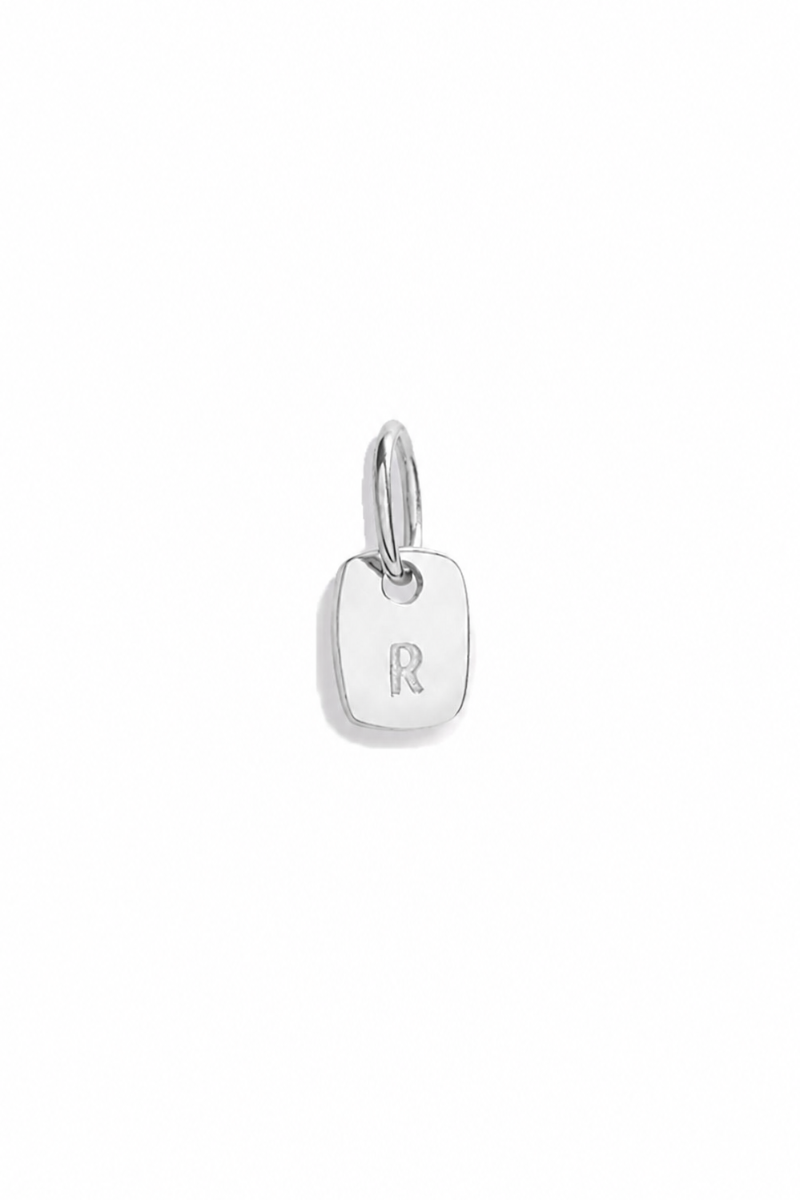 A sterling silver mini rectangular pendant with pre-cast letter R on it
