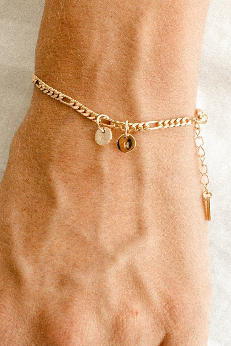 A figaro chain bracelet with a classic round Petite Gold Vermeil Initial Pendants from Bluebird Jewellery, personalised with your chosen letter and designed to be worn elegantly on any necklace, bracelet, or anklet chain.