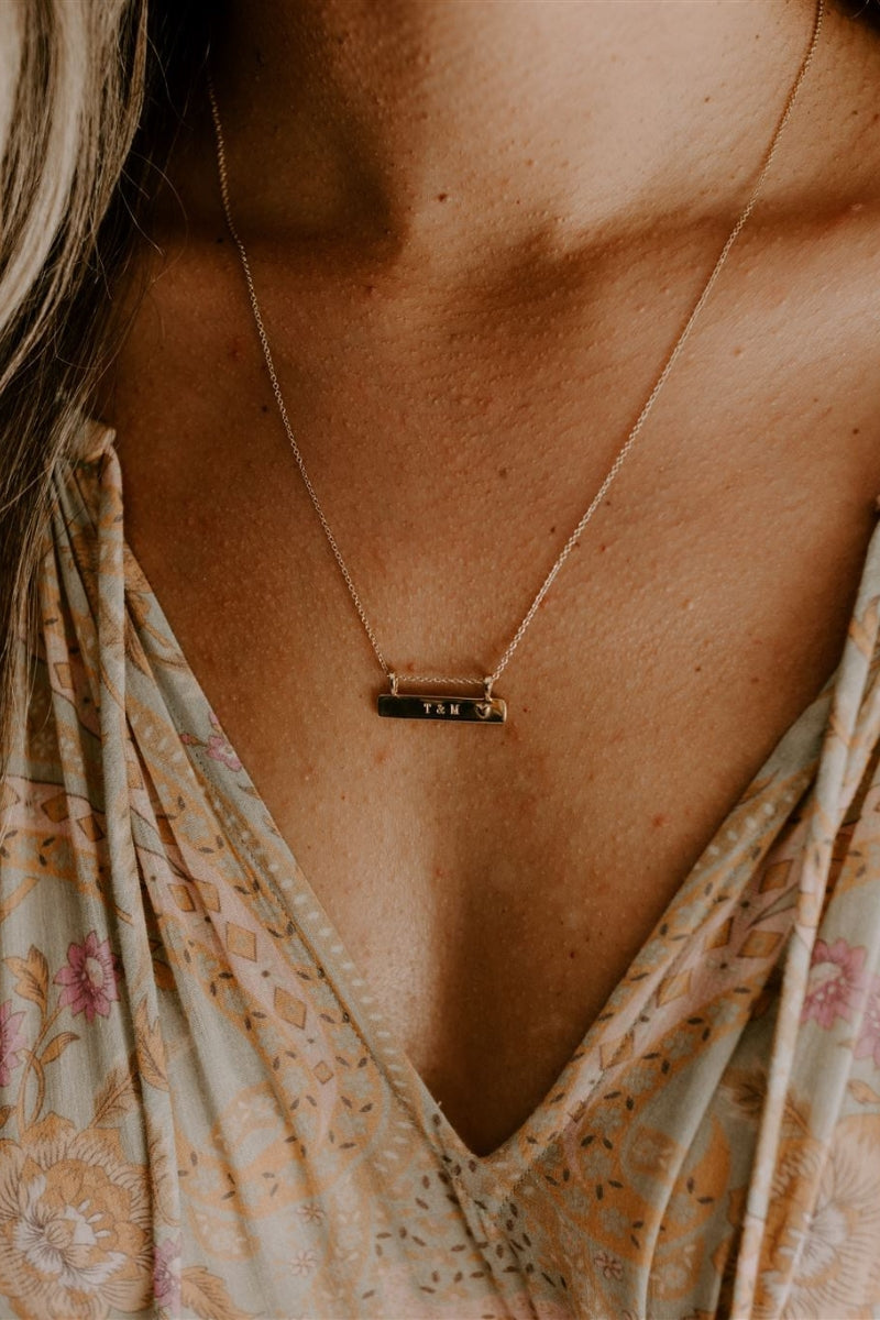 A Darling Bar Necklace has personalised engraving on the front surface and is worn at the 45+5cm length.