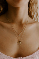 A teenage girl is wearing the Petite Darling Necklace in the child length of 35+5cm payered with the Darling Necklace in the 45cm length.  The two necklaces compliment one another and both feature the smooth, matte finish with finely raised edges and an organic surface.