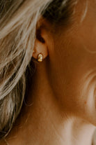 Petite Huggie earrings worn with Petite Daisy studs both in gold plated sterling silver.