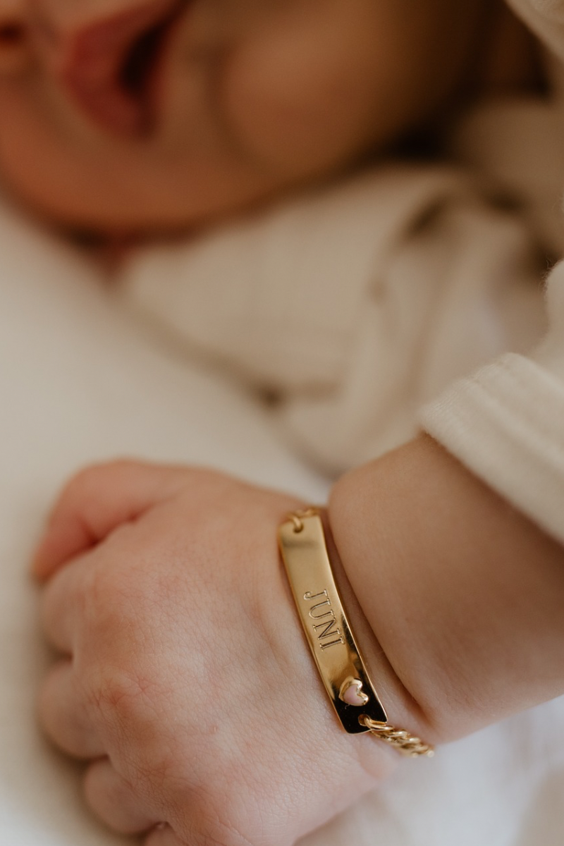 Pink Darling Bracelet on a baby's writs with detailed engraving shown. Personalised baby bracelet with a name engraved on it by Bluebird Jewellery.