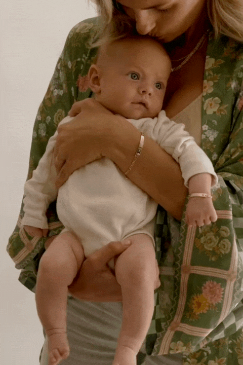A timeless moment between mum and baby, captured in matching Pink Darling Gold engraved bracelets by Bluebird Jewellery.