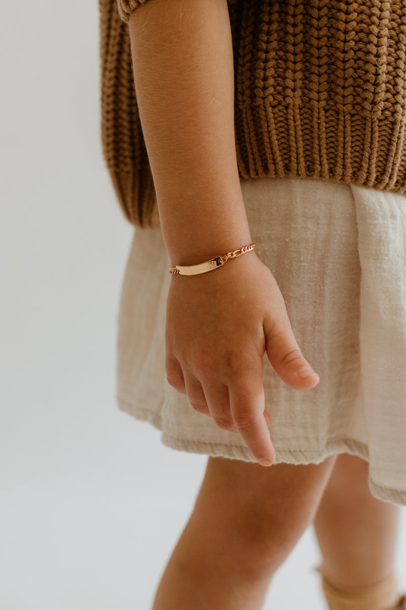 A five year old girl wears the Pink FDarling Bracelet in Rose Gold and she wears the child sized Bluebird Co personalised bracelet.