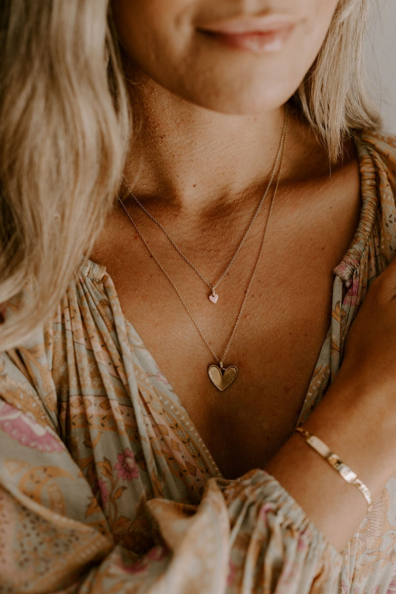 A mother wears the Pink Petite Darling Necklace layered with the Darling Necklace.