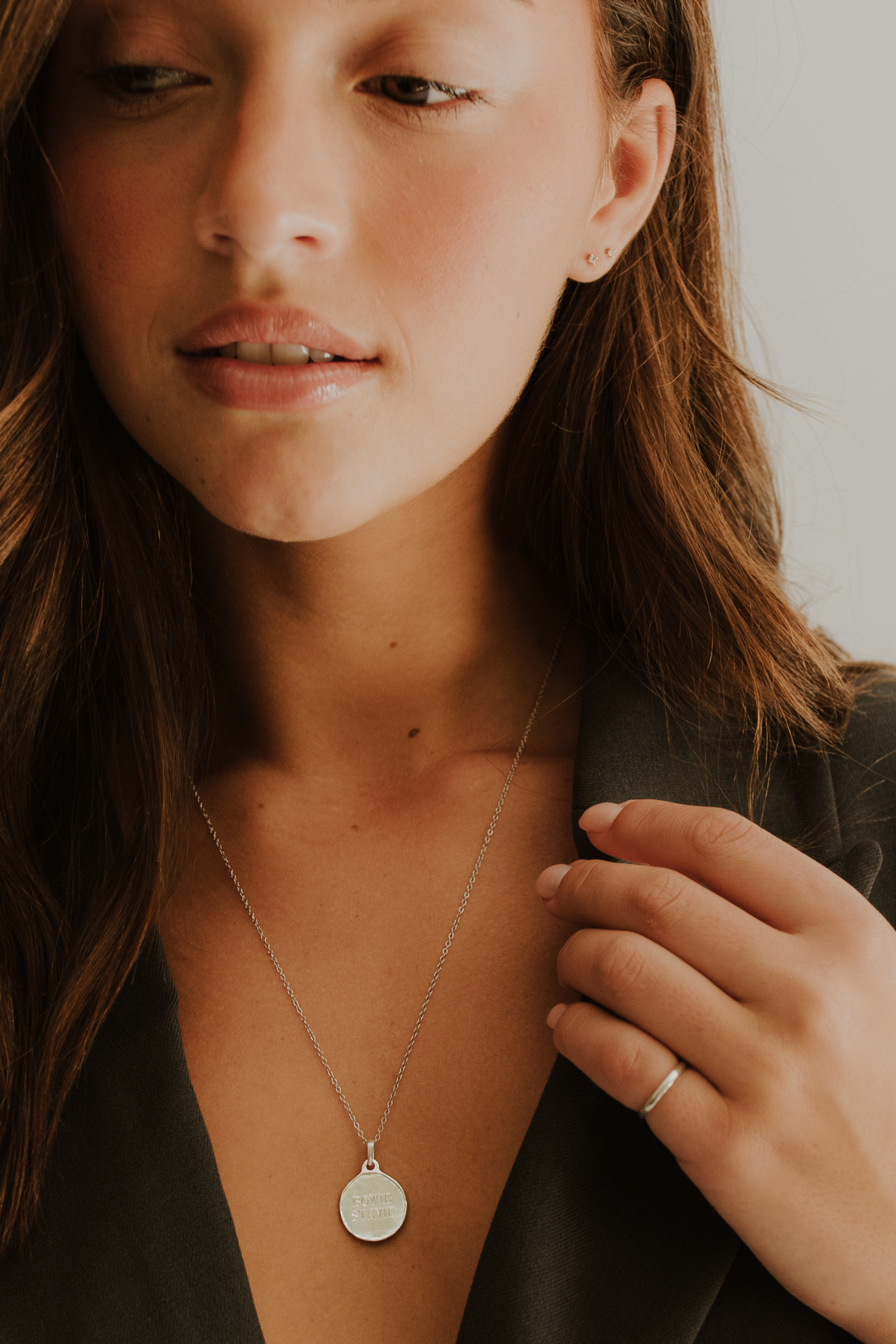 A woman is wearing an elegant silver band on her pinky finger.