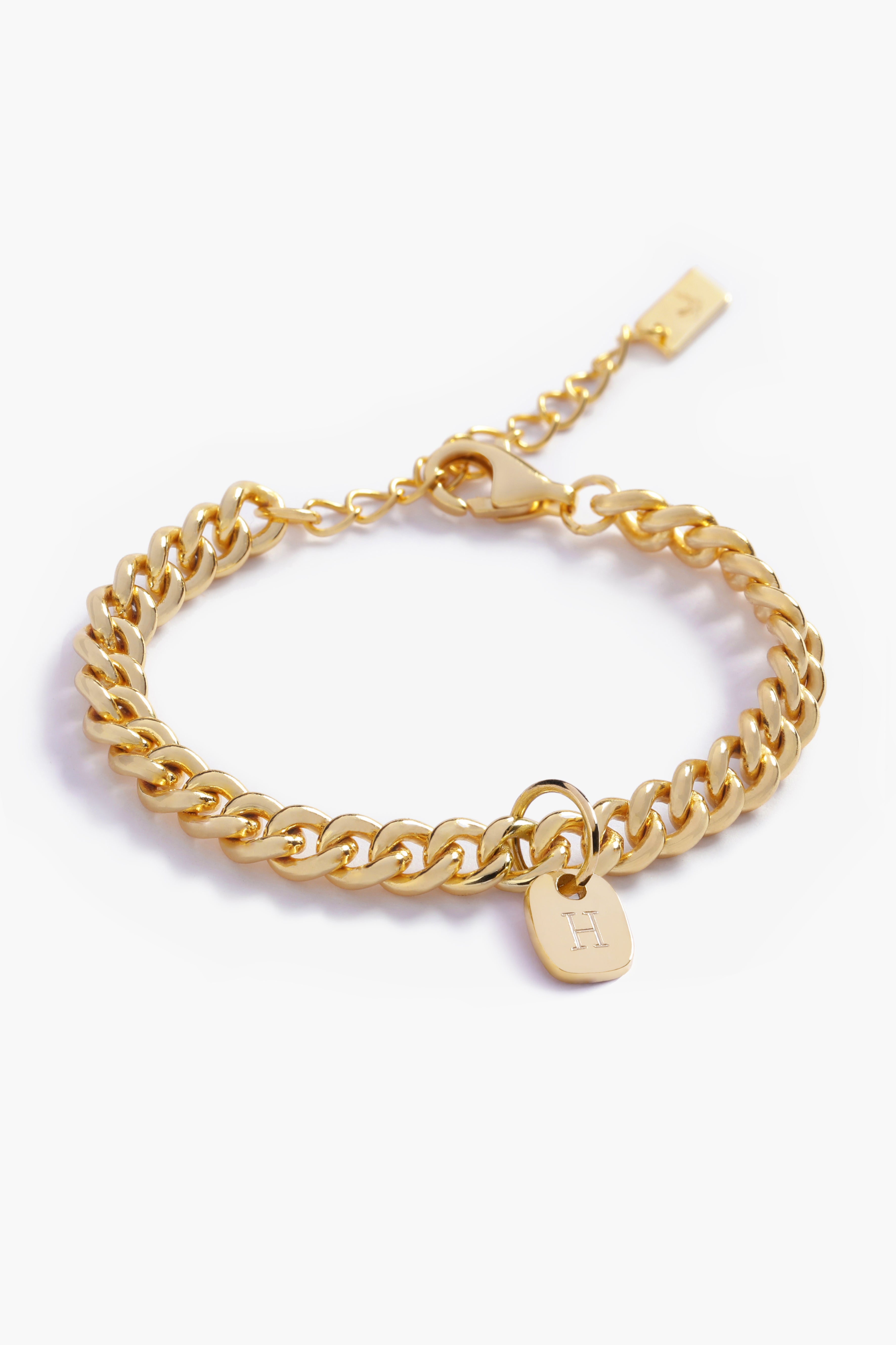 A close-up image showcasing the texture of a gold Cuban Link Chain and soild gold rectangular pendant, designed in elegant minimalist style by Bluebird Jewellery.