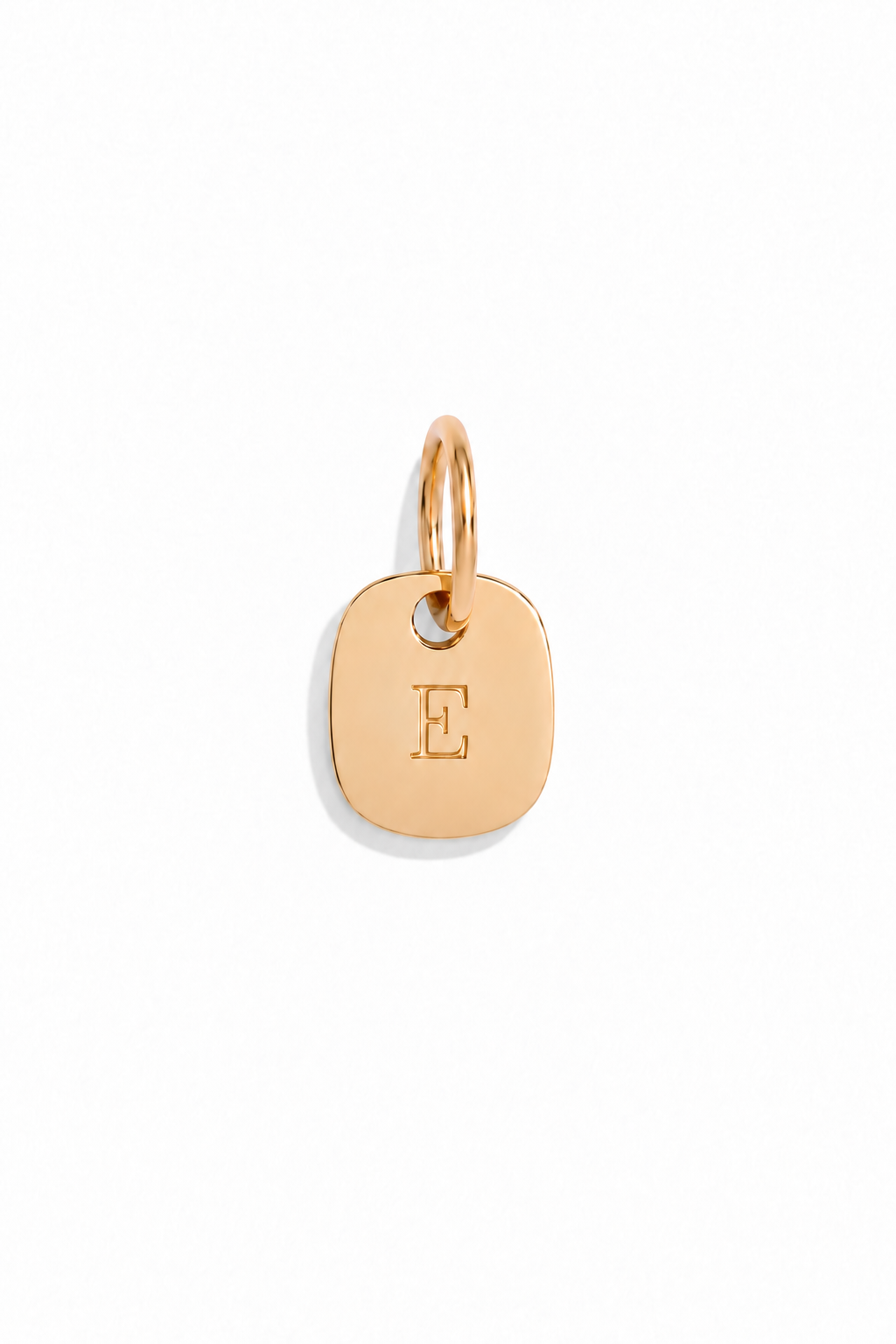 A solid gold initial pendant with curved edges and rectangular shape. machine engraved i=using diamond tip engraving method.