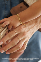 A 2mm Signature Ring in size 7 is worn on a woman's middle finger and is placed next to the 1.5mm Signature Ring and 2mm Pinky ring.