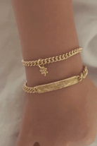 Bluebird Co's signature bracelet, daisy pendant, and cuban link in gold with engraving. 