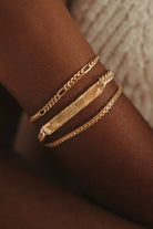 A close up view of the Signature Bracelet in Gold Vermeil.  It is worn in between the Figaro Bracelet and Lace Chain Bracelet.