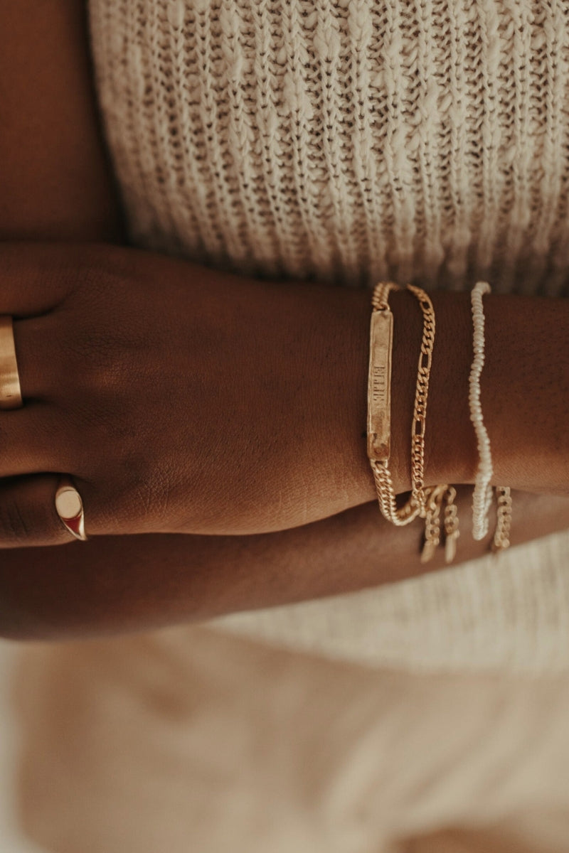 A close up of a Signature Bracelet with a name engraved on it.