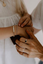 A mother is wearing a solid gold signet ring on her pointer finger.  She is also wearing the Vintage Pearl Signet ring on her Pinky Finger.