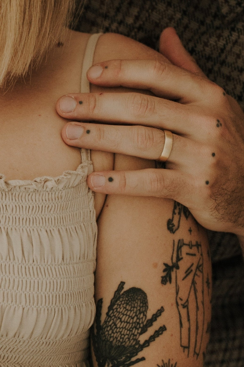 A husband holds his wife's shoulder and he is wearing his Signature Men's Ring in size 10 on his ring finger.