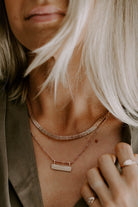 The Signature Statement necklace is layered with the Signature Bar Necklace.