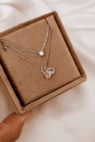 A Silver Lume Necklace sits in a gift box with a Petite Personalised Necklace with two persojnalised initial pendants.  The two necklaces compliment each other and offer a lovely layered necklace look.