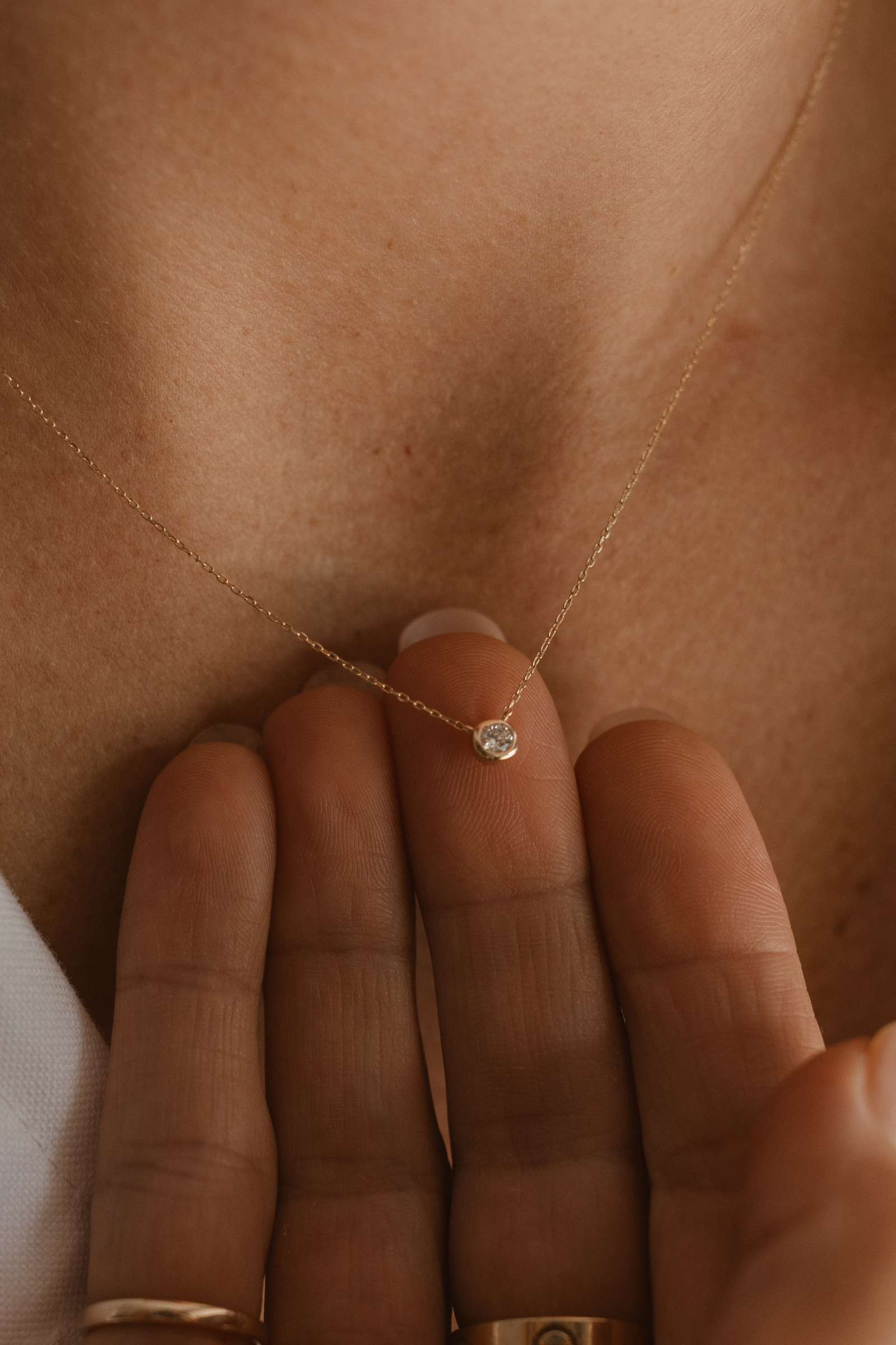 A close-up of the Lumé Necklace by Bluebird Jewellery, inspired by the French word for ‘light,’ crafted as a radiant symbol of warmth and kindness.