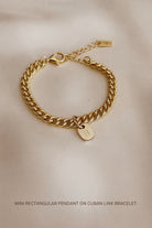 The Cuban Chain Bracelet with Mini Rectangular Pendant by Bluebird Jewellery features gentle curves and a luxe, modern silhouette. Personalised with your chosen letter, it embodies feminine elegance and can be worn beautifully on any necklace, bracelet, or anklet chain.