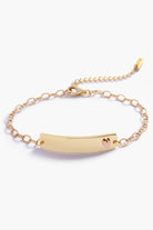 Gold bracelet with a heart charm on a white background