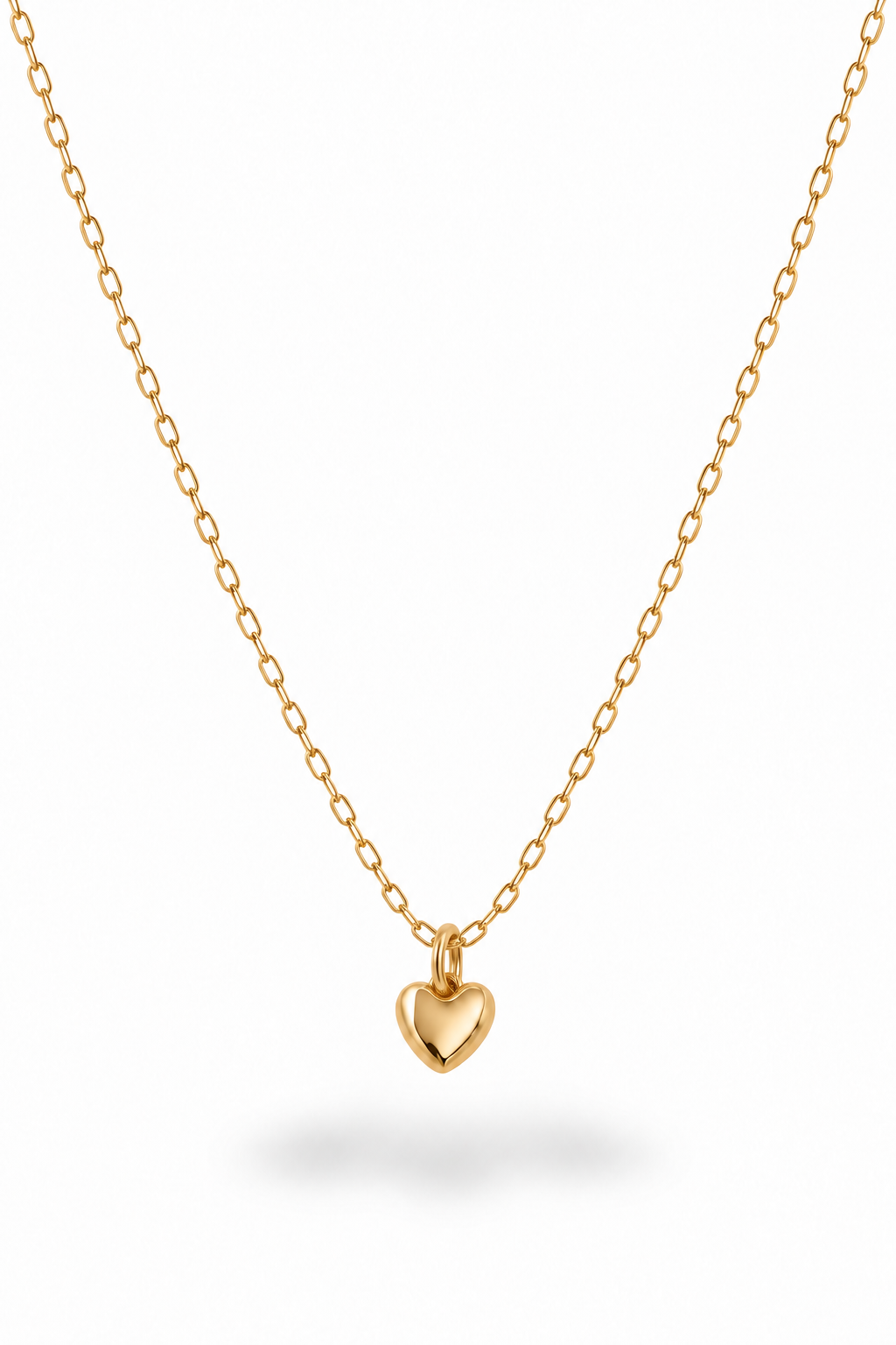 A delicate gold chain necklace with a small, polished gold heart pendant, displayed against a clean white background with a soft shadow underneath.