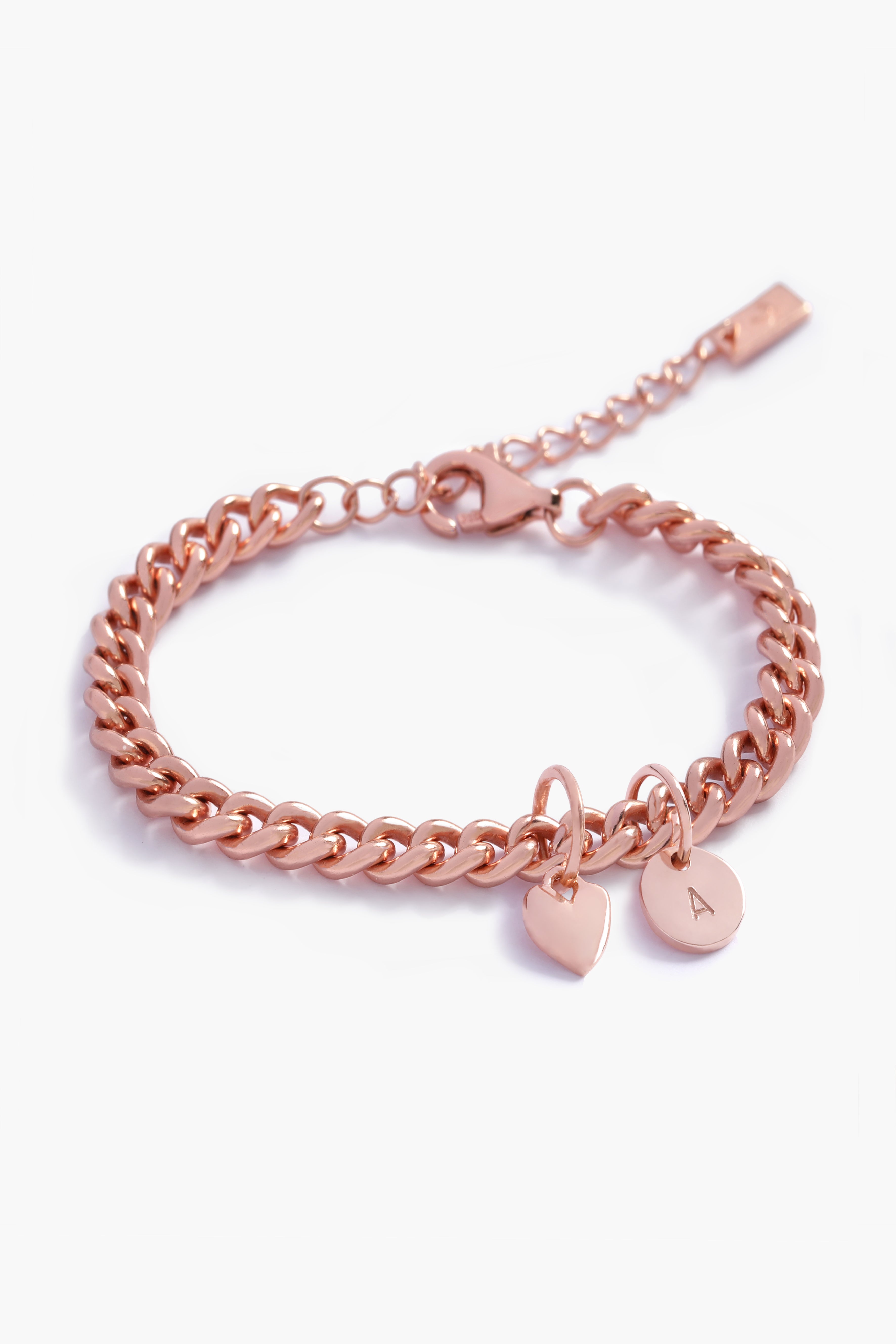 A rose gold Sweetheart Cuban Link Chain Bracelet adorned with a heart charm and engraved initial pendant, designed as a timeless personalised keepsake.
