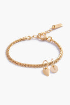 A personalised gold bracelet featuring a lace-like chain with a heart charm and solid gold letter pendant, designed as elegant fine jewellery for all ages.