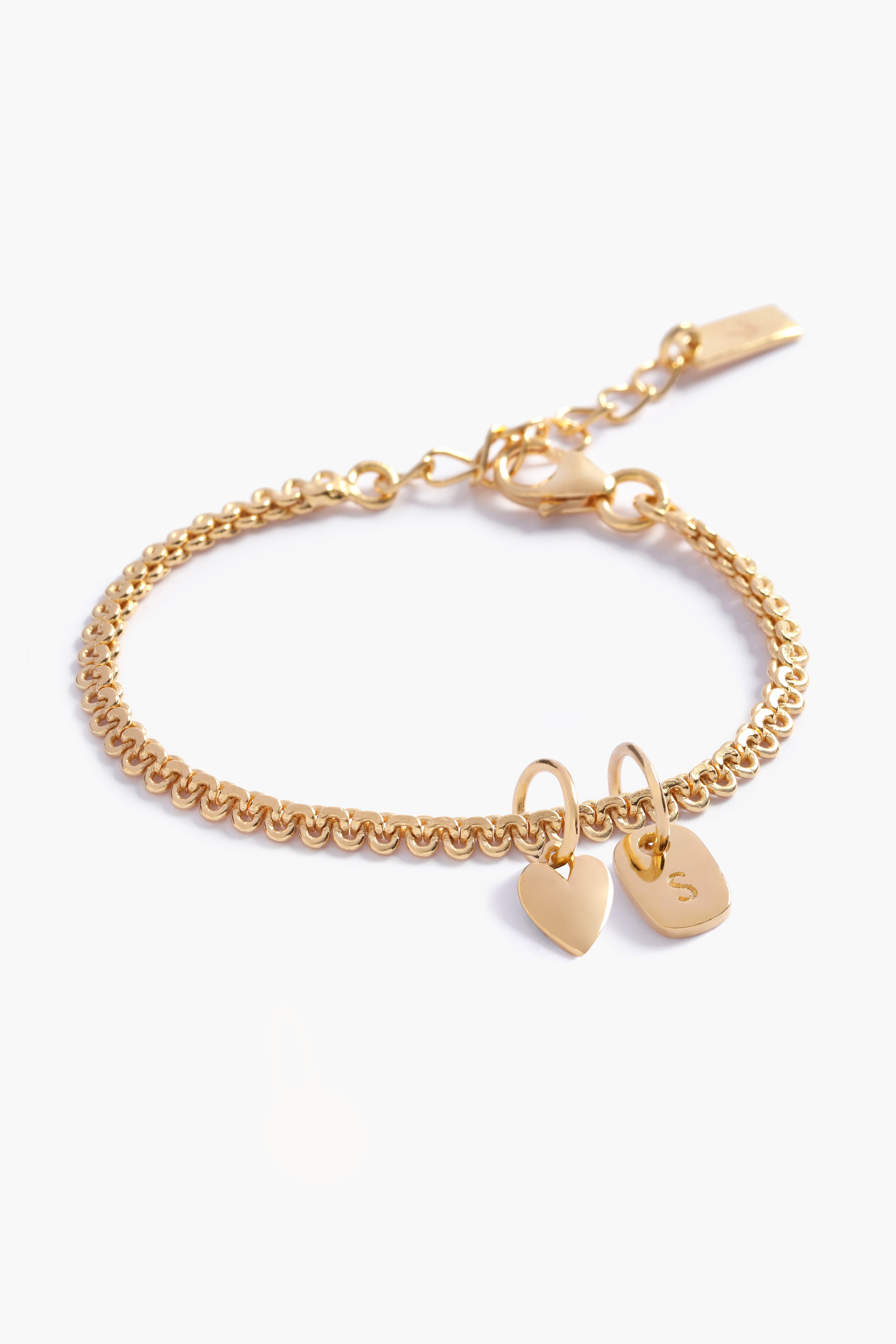 A personalised Lace Chain Bracelet featuring a heart charm and soild gold rectangular initial pendant, designed as an elegant fine jewellery gift for all ages.