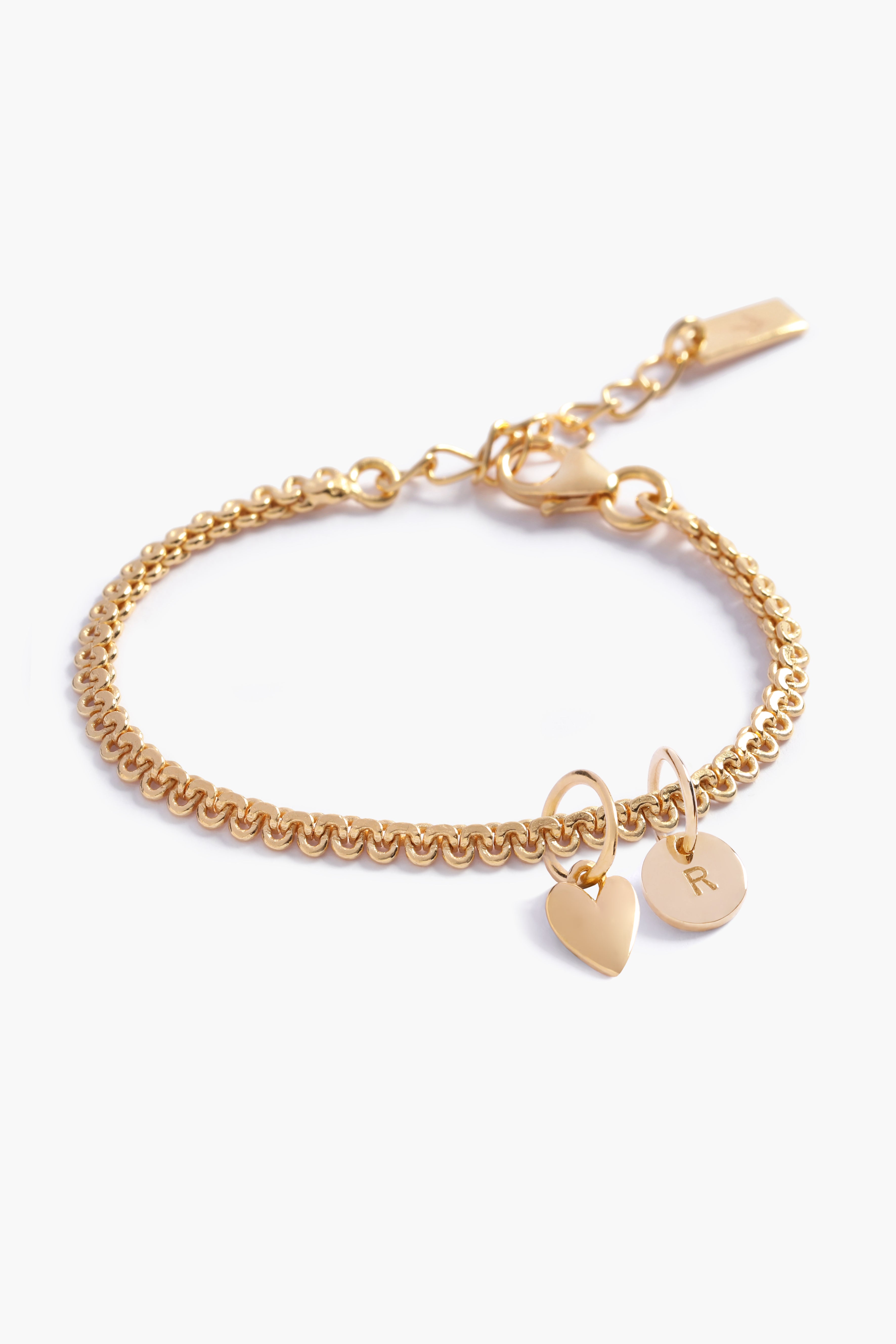 A personalised gold bracelet for a baby, child or adult that features a lace looking chain with a mini heart pendant and a personalised solid gold initial pendant. A perfect baby gift with personalised letter pendant.