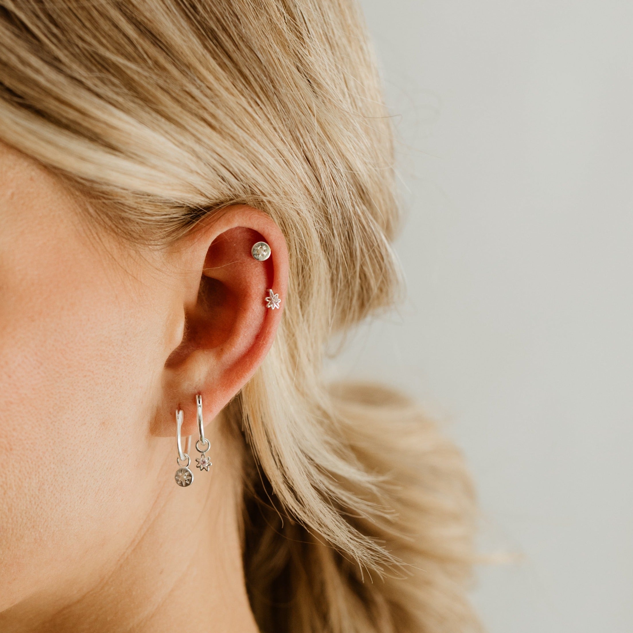 The Petite Daisy Stud is worn with the Petite Vintage Pearl Stud in the ear cartilage while the Vintage Pearl and Daisy Hoops are worn on the ear lobe. 