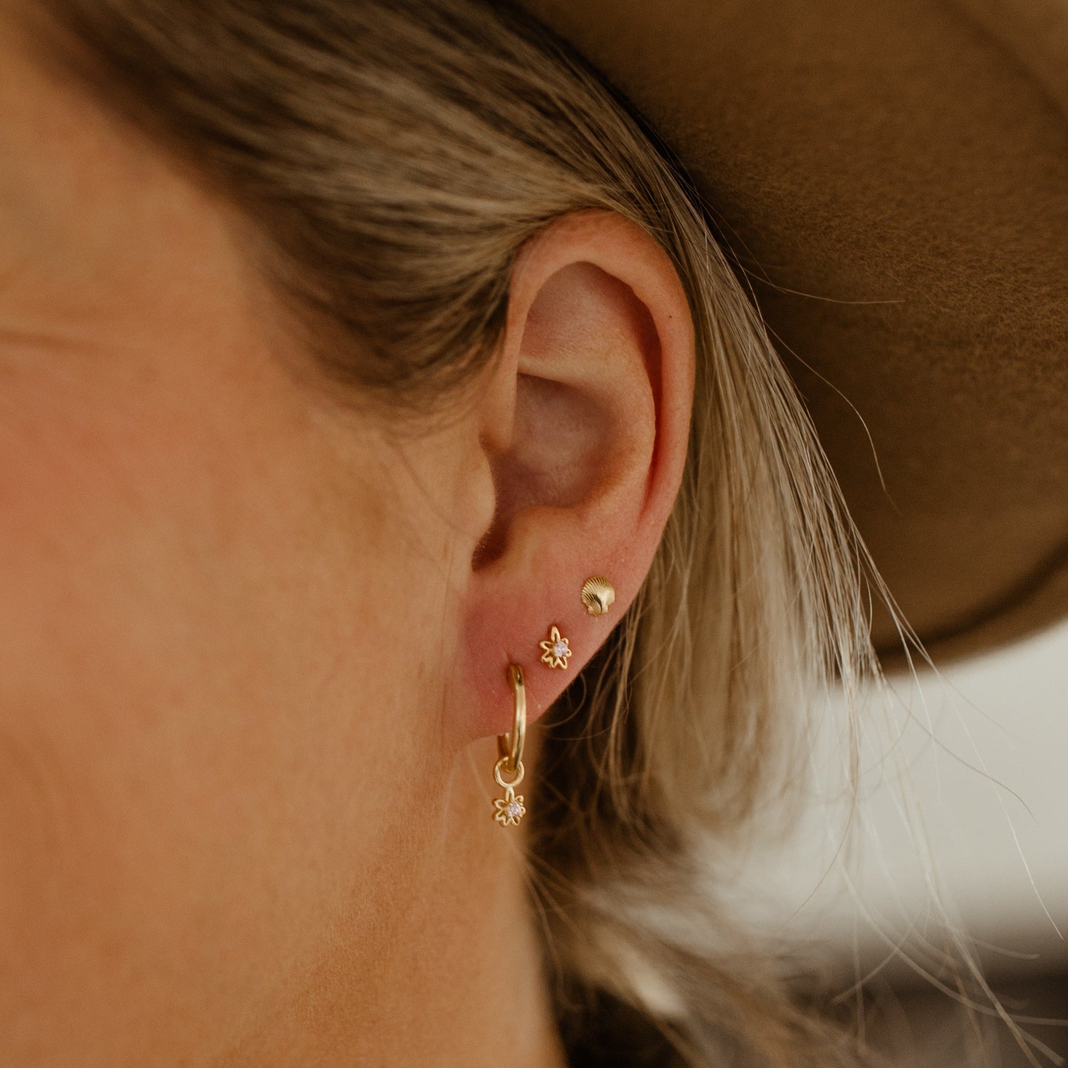 Gold Vermeil Petite Daisy Hoop and Petite Daisy Stud worn as a layered pair in a woman's earlobe. They pair together well as the Petite Daisy charm matches the stud earring.