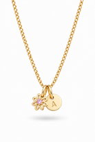 A gold chain necklace featuring a small gold flower charm with a pink gemstone and a round gold initial 'A' disc charm, shown on a clean white background.