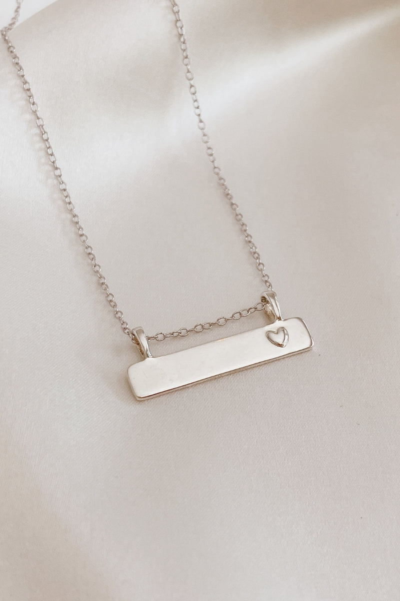 Sterling silver Darling Bar Necklace with engraved heart charm, designed for everyday wear. 
