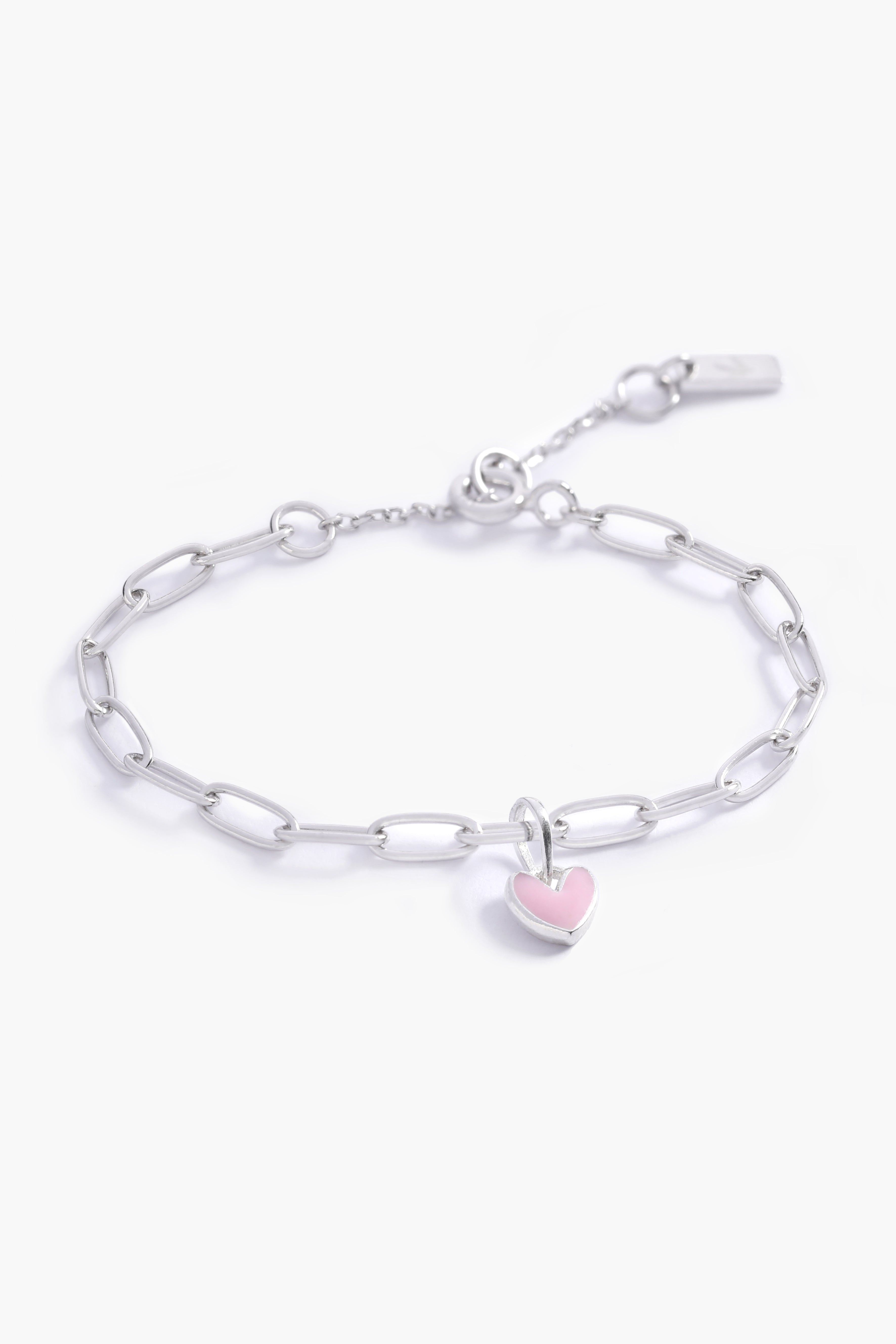 A close-up of a Darling Posie Bracelet by Bluebird Jewellery with a pink heart pendant on a sterling silver chain, designed in timeless fine jewellery style.