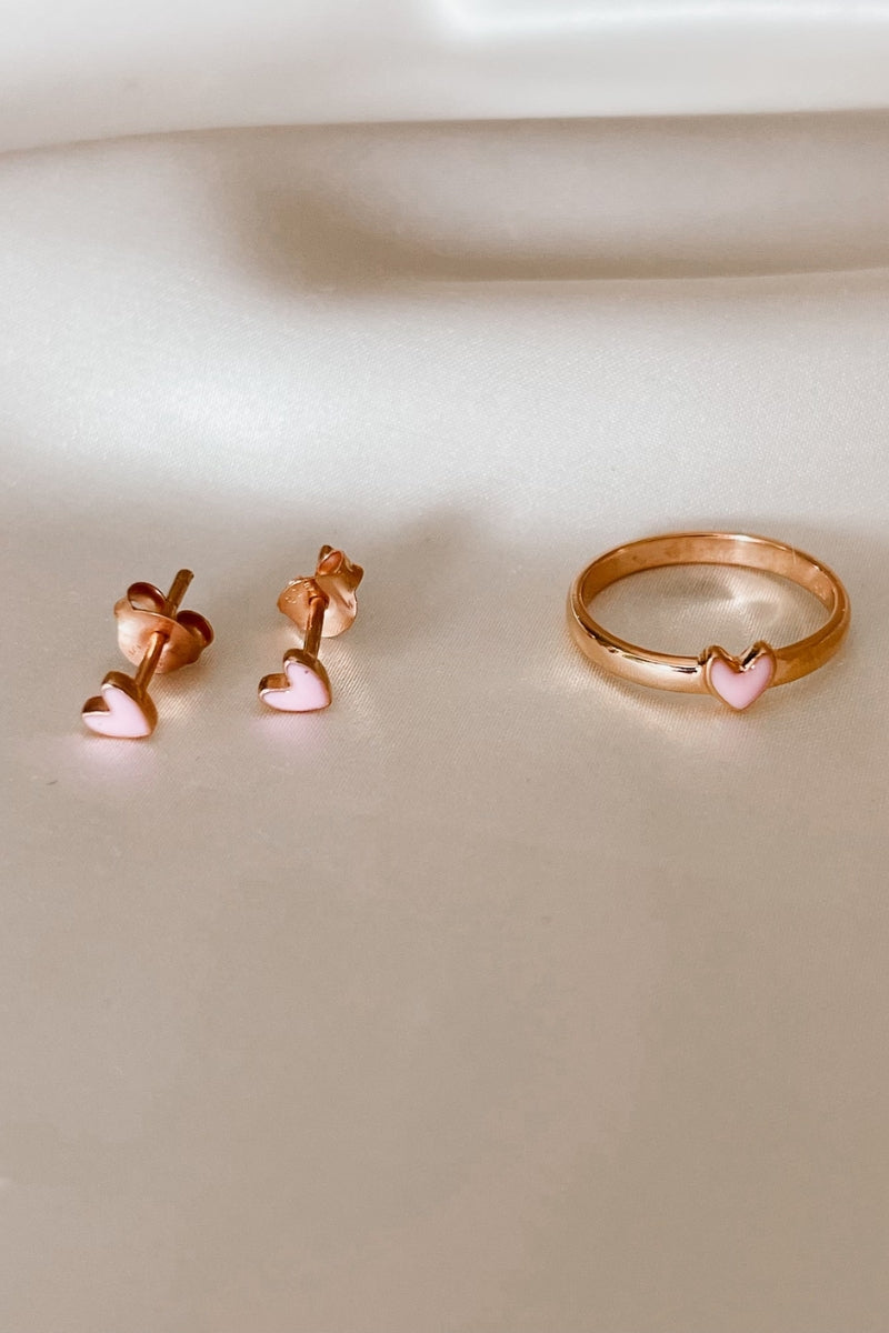 Pink heart rose gold ring displayed beside matching earrings.