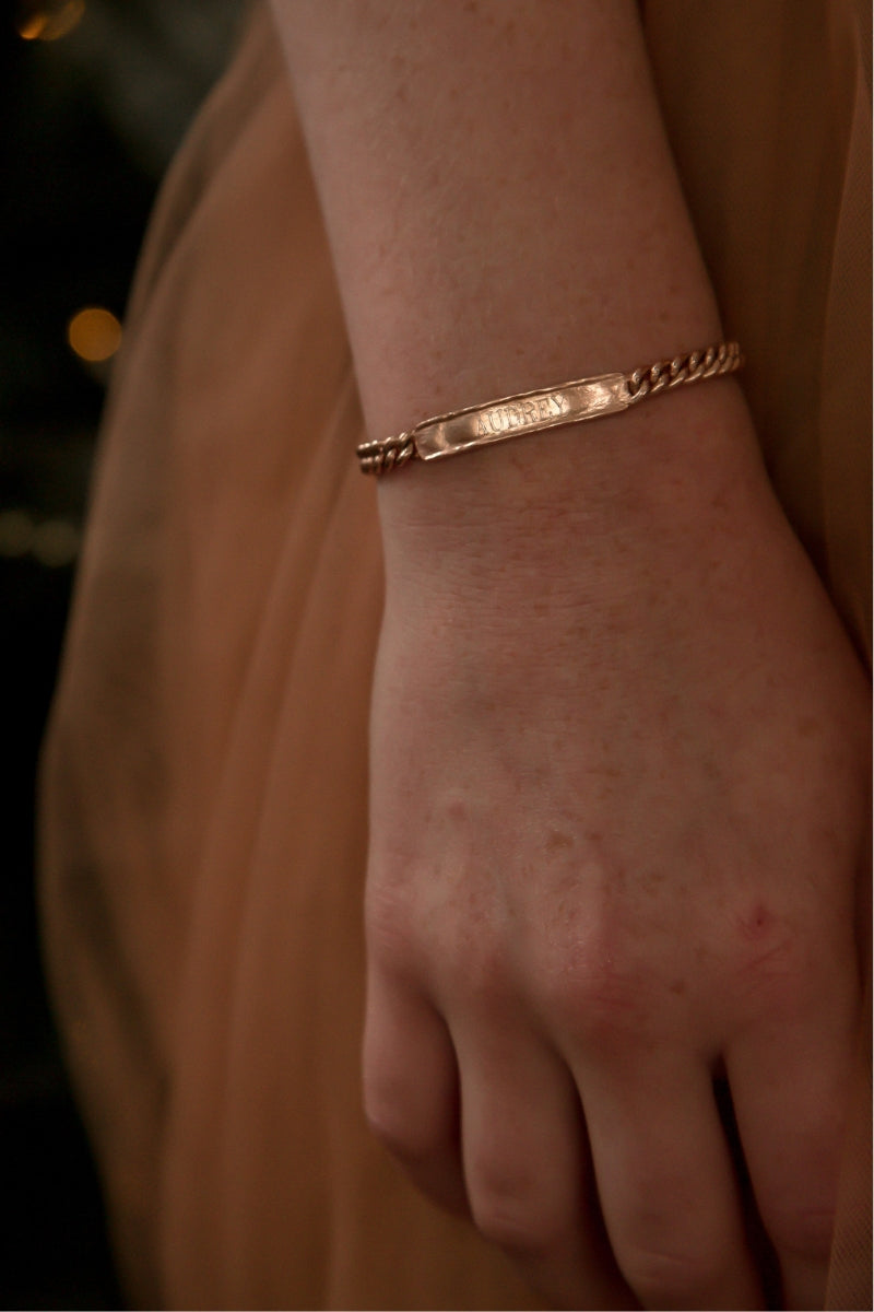 Signature bracelet in rose gold styled on wrist, featuring custom engraving and secure clasp for daily wear