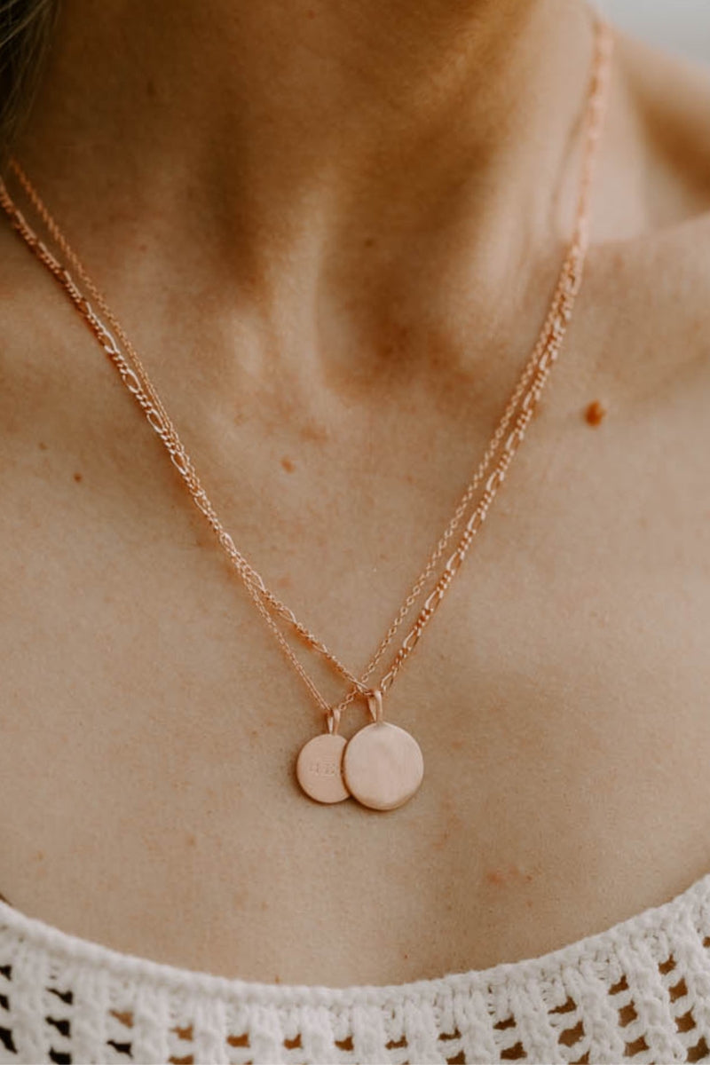 Layered Petite Signature Necklaces in rose gold with custom engravings, styled with different chain lengths on the chest.