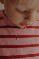 Pink Petite Darling gold necklace worn by child with pink heart pendant