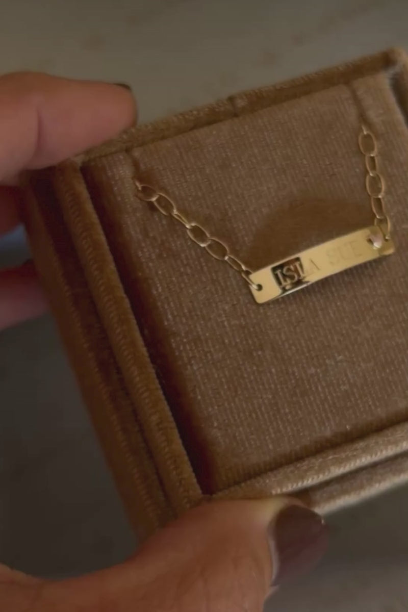 A close up look at the Solid Gold Pink Darling Bracelet inside the velvet Bluebird Co gift box