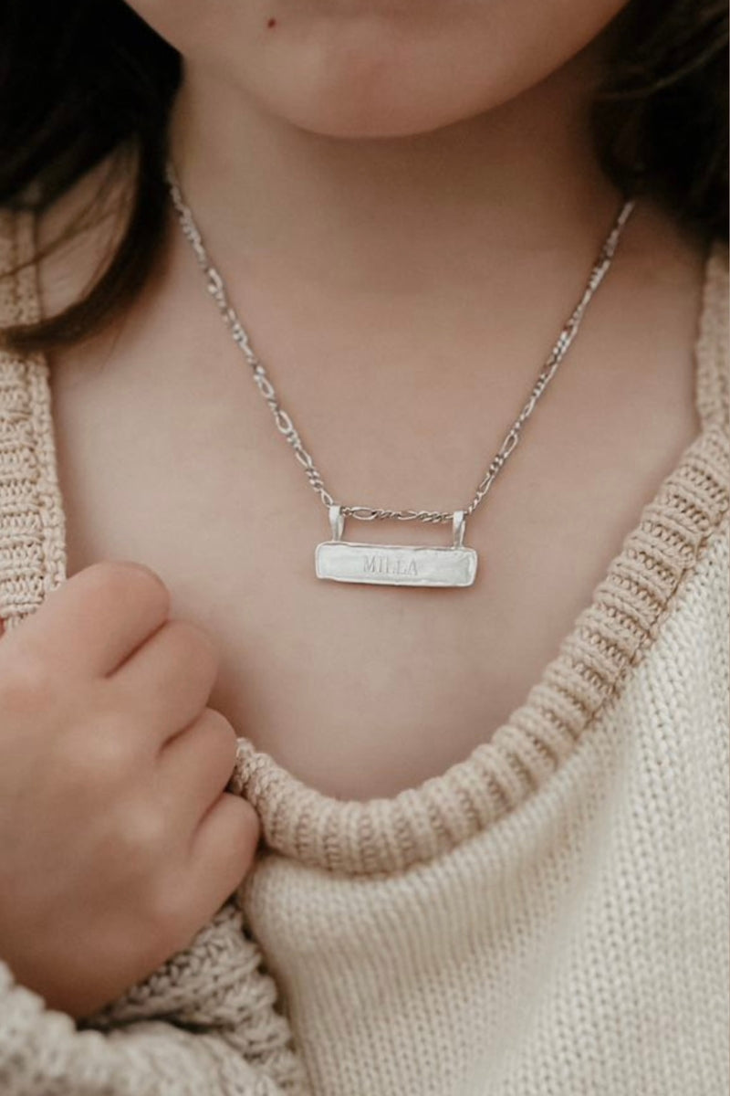 Signature Bar Necklace Silver worn by a child, engraved with the name “MILLA”. A beautiful personalised necklace for kids and special moments.