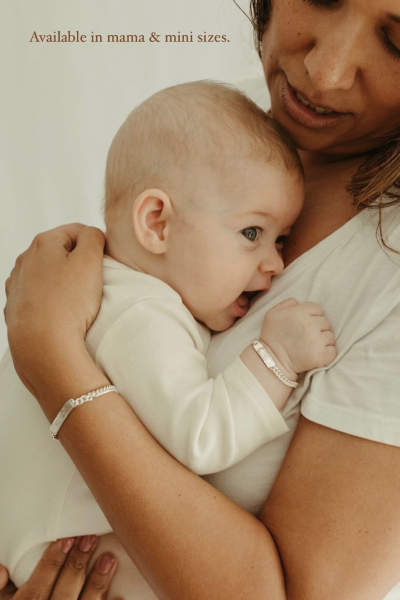 Mum and baby wearing matching engraved silver signature bracelets, shown in mama and mini sizes
