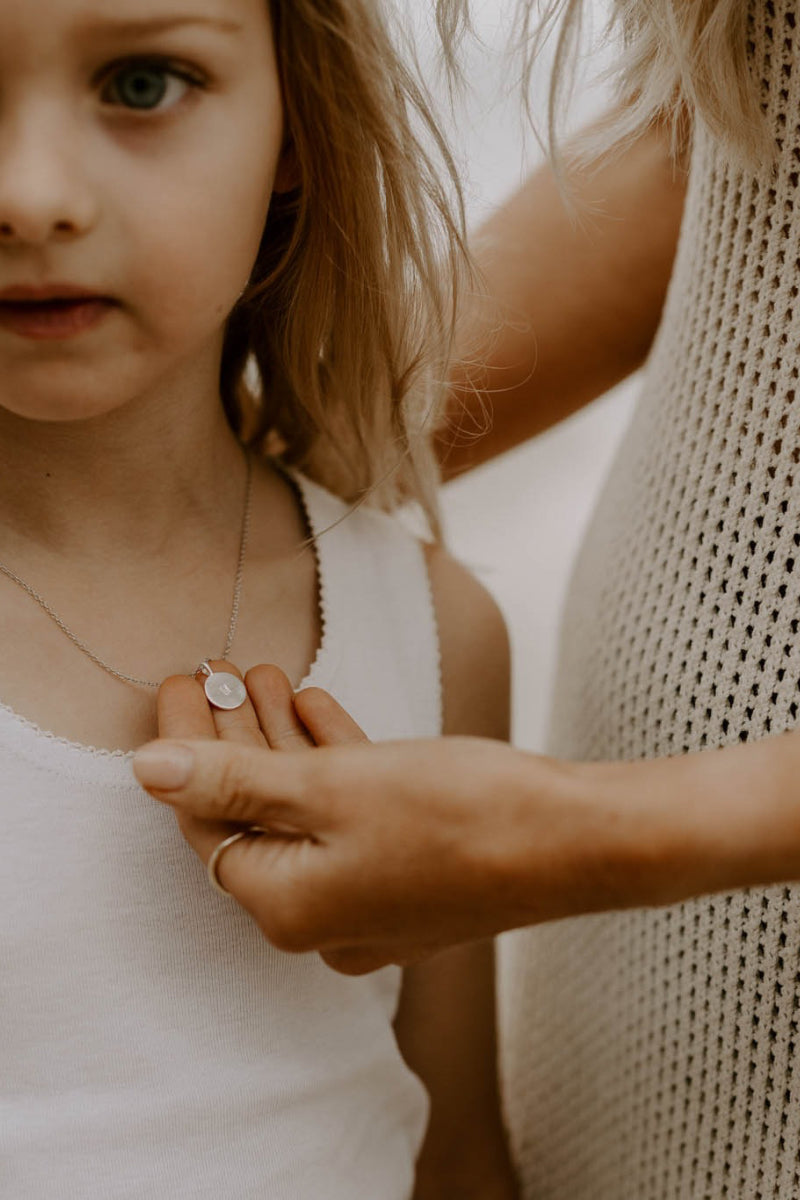Engraved silver initial necklace on fine chain, a sentimental gift for girls to treasure and wear daily.
